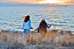 Girls on the beach during sunset in fall