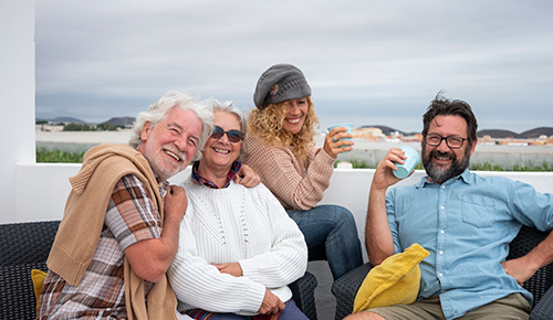 Group of happy adults in cooler weather enjoying home in the Seaside Park real estate market