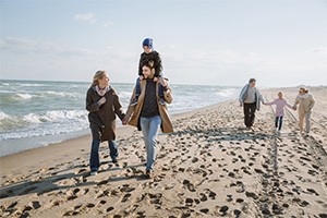 Family enjoying a walk on the beach in winter after finding their dream home among homes for sale in Seaside Park