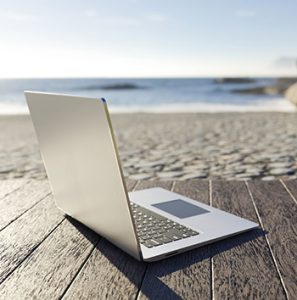 Laptop on a table on the beach; work from home in the Seaside Park real estate market